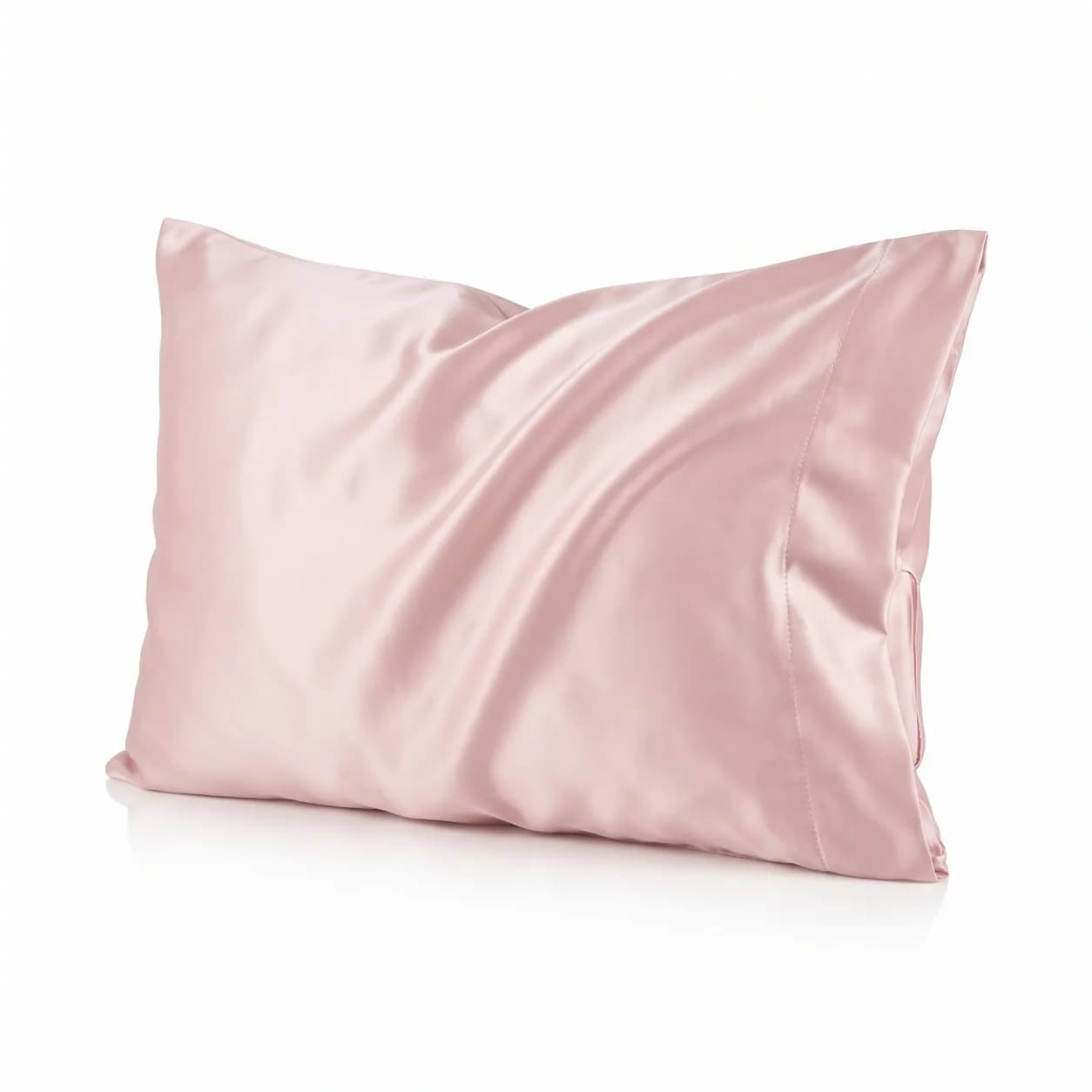 Blush pink satin pillowcase on a pillow, showing the smooth sheen and envelope closure